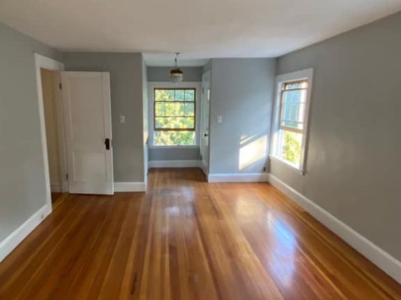 A finished room: pale grey walls, white trims and a polished timber floor