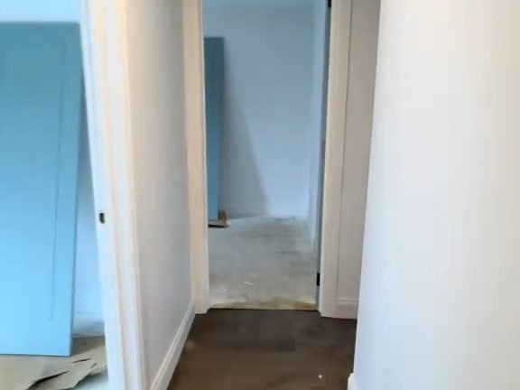 A hallway ZX repainted: white walls and doors beside a blue feature wall