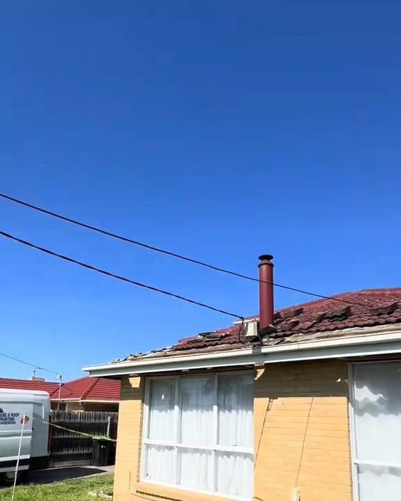 A brick house in Springvale under a clear sky, its tiled roof about to be repaired